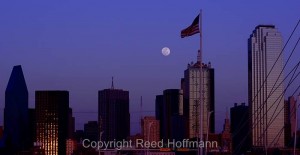 A tighter shot of the moon and skyline, with the setting sun reflecting off some windows. Nikon D5200 set to white balance of COOL WHT FL and ISO of 200, shutter speed of 1/400 at f/6.3, with exposure compensation at  0.0, 70-300mm f/4.5-5.6 lens. Photo copyright Reed Hoffmann.