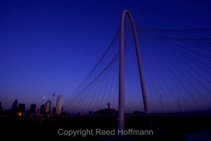 Margaret Hunt Hill Bridge with the Dallas skyline behind, and the moon rising. Nikon D5200 set to white balance of COOL WHT FL and ISO of 200, shutter speed of 1/320 at f/6.3, with exposure compensation at  0.0, 10-24mm f/3.5-4.5 lens. Photo copyright Reed Hoffmann.