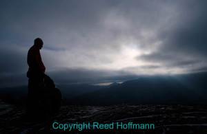 Watching the sun headed down through storm clouds from a summit. Photo copyright Reed Hoffmann.